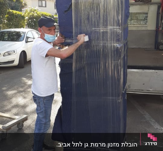 אדם עוטף רהיט בניילון לעטיפה